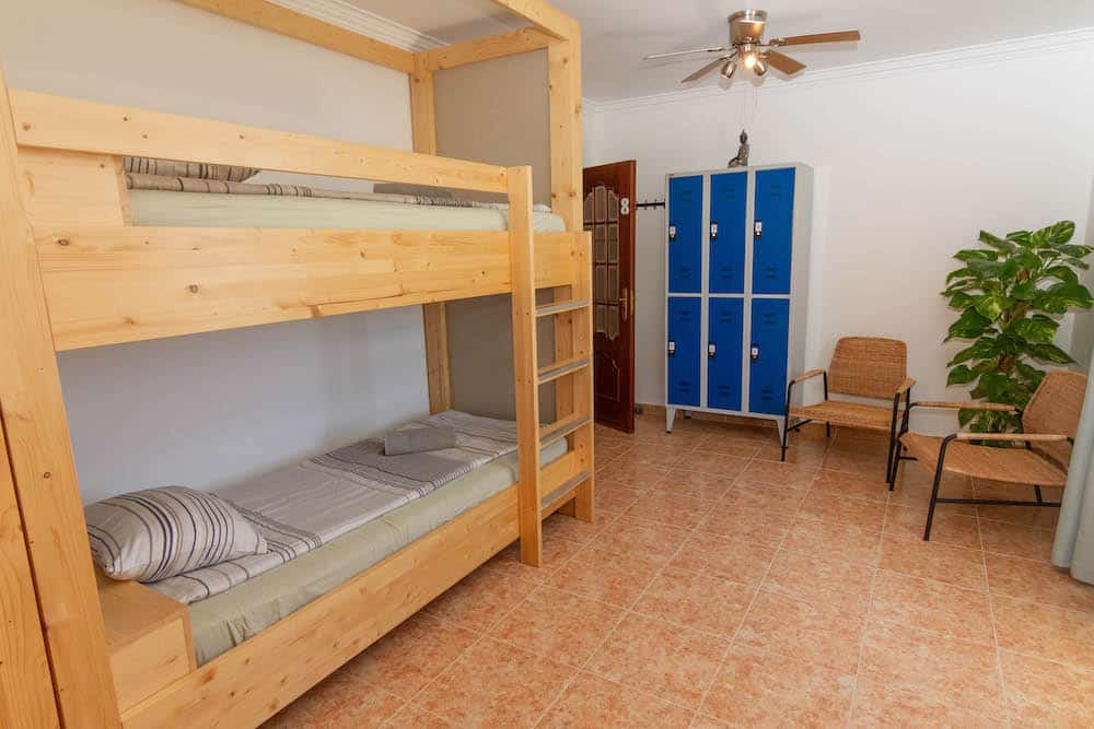 Dorm room with bunk bed, ceiling fan, safe and chairs